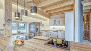 A modern kitchen with wooden beams, stainless steel appliances, and a large island with fruit bowl and sink. - 3 bedroom stunning home in Sittensen Kalbe (Sittensen Kalbe)