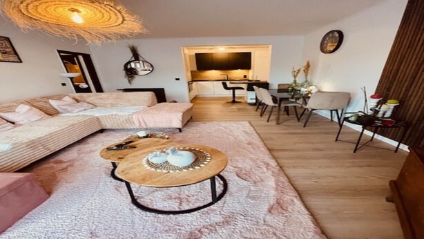 Un salon moderne avec un canapé, une table basse et un coin repas.