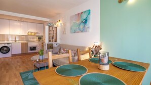 A modern apartment with a dining area, kitchen, and living space. - Alba de la Luna Apartment (Albuñol)