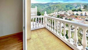 A balcony with a white balustrade overlooking a town with buildings and hills. - Alba de la Luna Apartment (Albuñol)