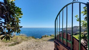 Blick auf die Küste mit einem Metallzaun, der zum Strand führt.