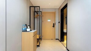 A narrow hallway with a wooden cabinet, a black metal structure, and a door at the end. - GreenTree Inn Express Hotel (Shanghai Songjiang Sijing Subway Station) (Shanghai)