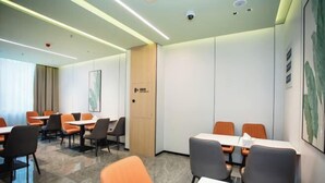 A conference room with tables and chairs, a wooden door, and a framed picture on the wall. - GreenTree Inn Express Hotel (Shanghai Songjiang Sijing Subway Station) (Shanghai)
