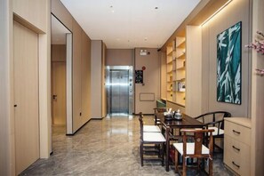 A hotel corridor with a dining area, a reception desk, and a view of the elevator. - GreenTree Inn Express Hotel (Shanghai Songjiang Sijing Subway Station) (Shanghai)