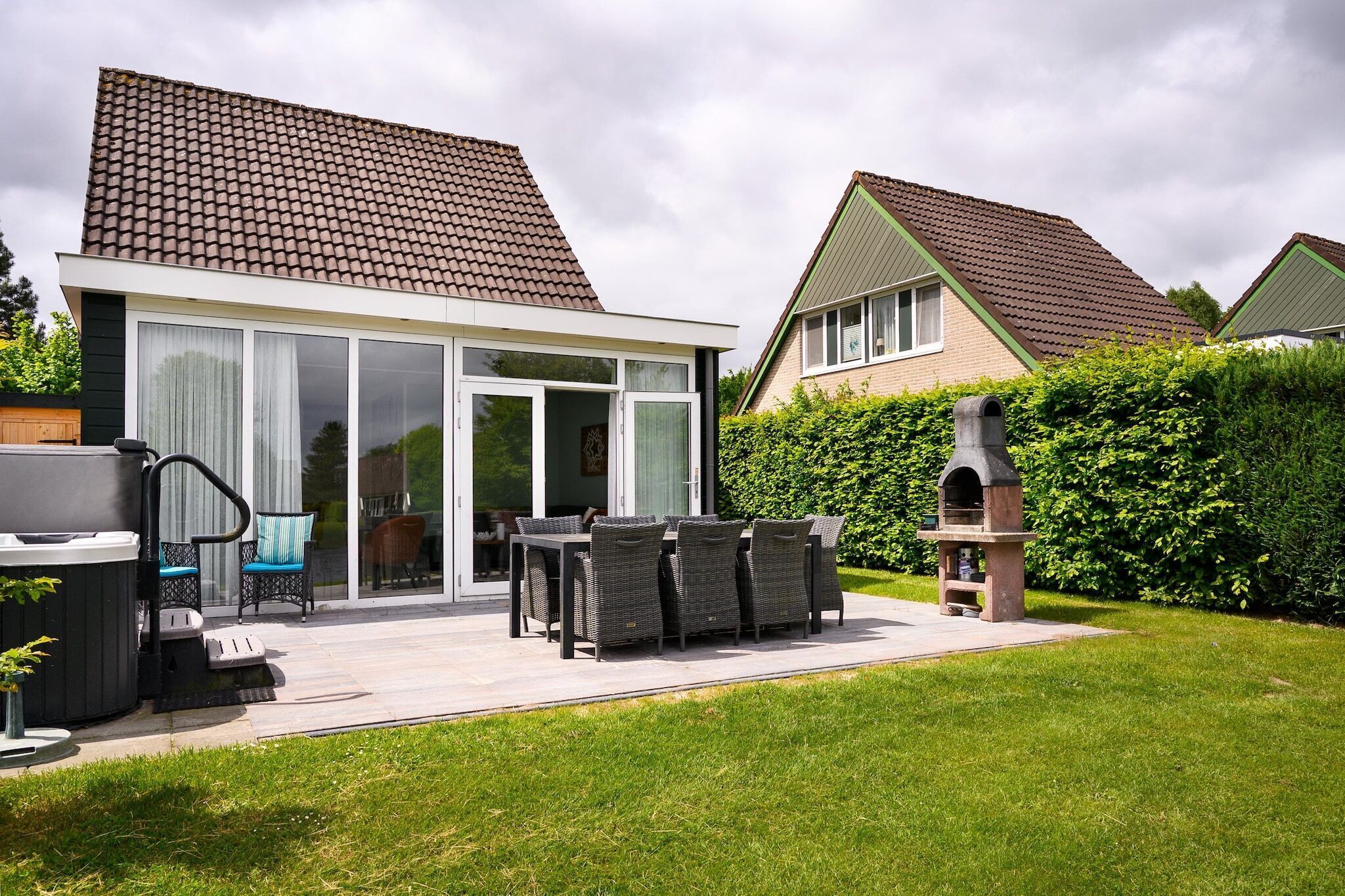 Una casa moderna con patio, idromassaggio e zona barbecue.