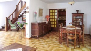 A wooden staircase, a dining table with chairs, a cabinet, and a vase with flowers. - Stunning home in Vedène (Vedène)