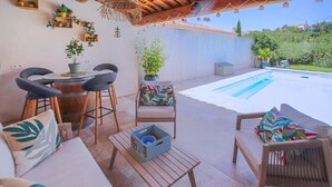 A patio area with a pool, outdoor seating, and potted plants. - Villa contemporaine Provençale (Mormoiron)