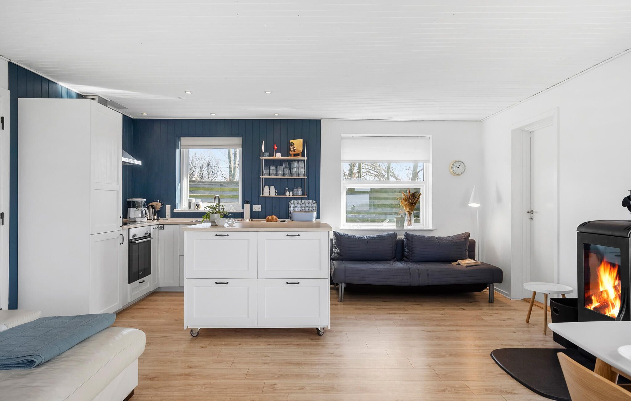 Een moderne leefruimte met een keuken, eethoek en een open haard.