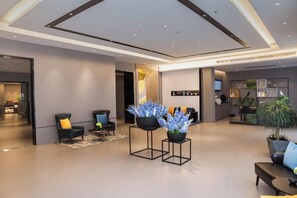 A modern hotel lobby with seating areas, a reception desk, and a large plant. - Home Inn Neo (Suzhou North High-Speed Railway Station Cailian Plaza) (Suzhou)