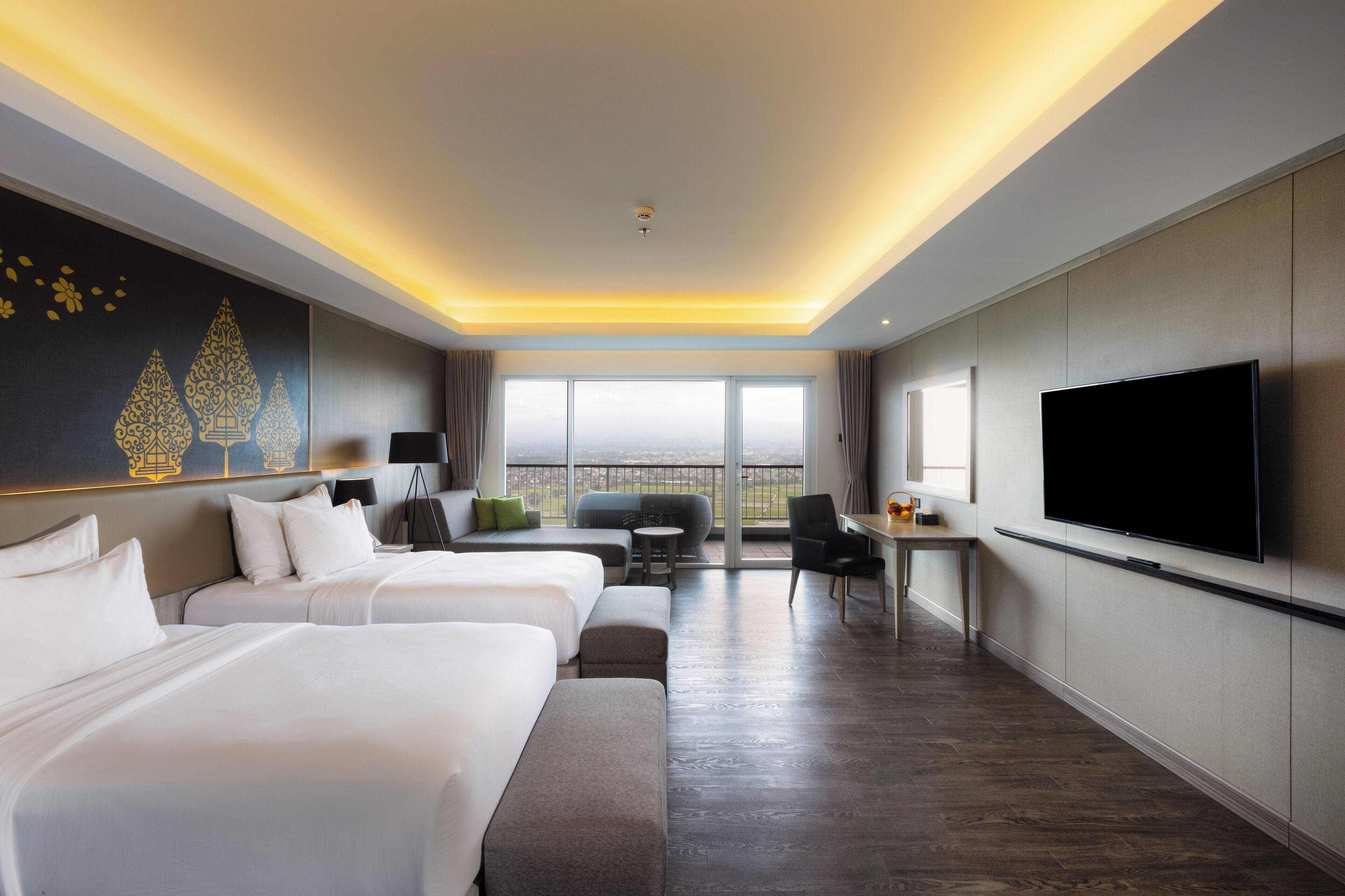 Habitación de hotel con dos camas, un sofá, un escritorio y una televisión.