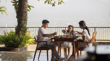 A family dining outdoors with a view of a cityscape.