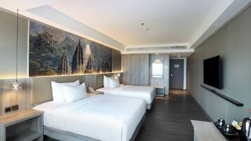 A modern hotel room with two beds, a large painting, a flat-screen TV, and a small kitchenette.