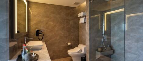 A modern bathroom with a glass-enclosed shower, a white sink, and a toilet.