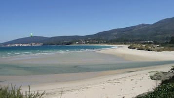 On the beach, white sand, sun loungers, beach umbrellas