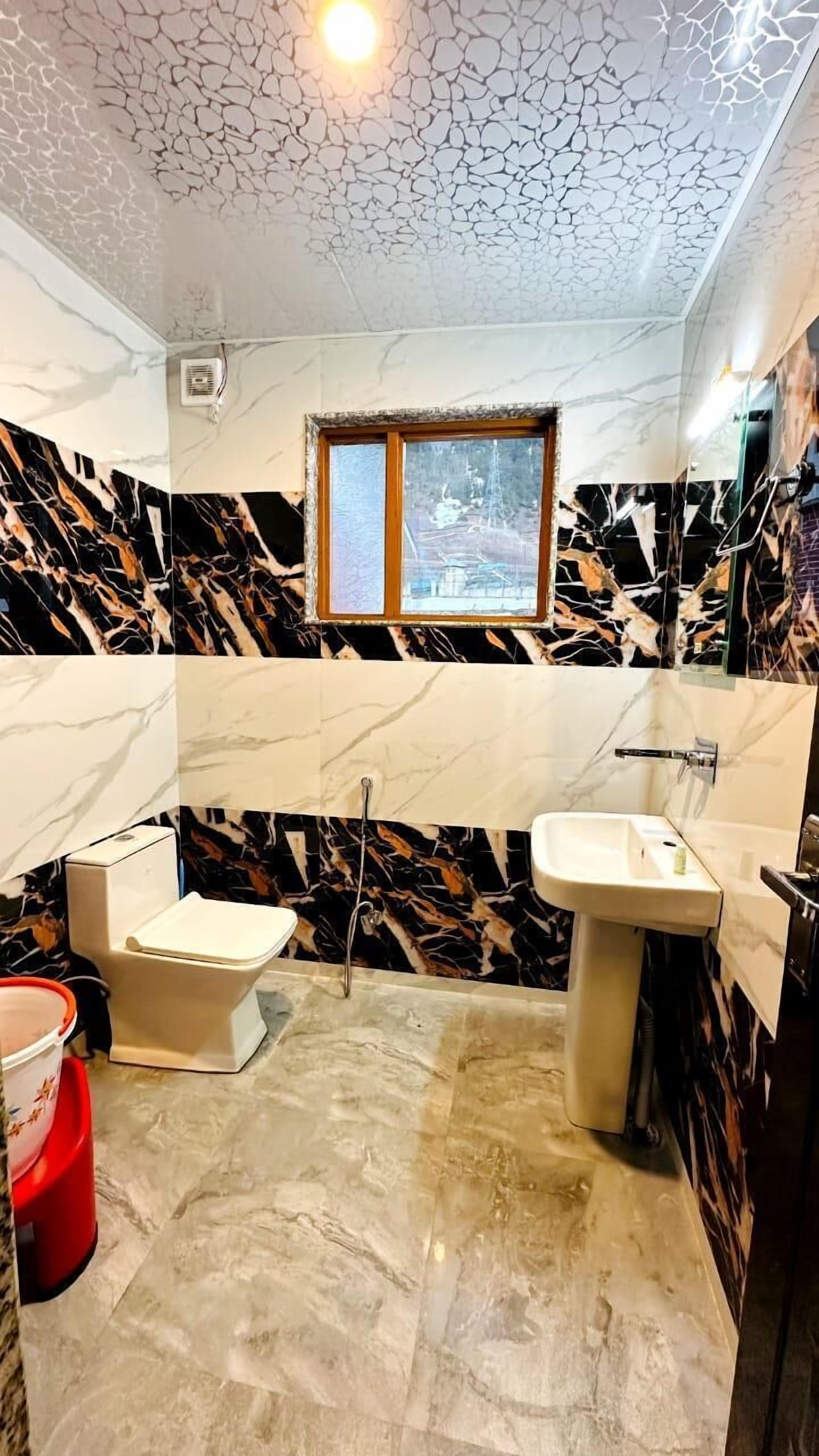 Un baño con inodoro, lavamanos y ventana.