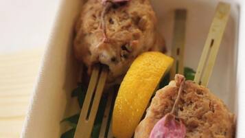 A food container with a biscuit and a lemon wedge.