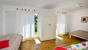 A room with two beds, a wardrobe, and a view through a door. - Holiday Home 'Kunterbunt' with Private Terrace, Shared Garden and Wi-Fi (Lindau)