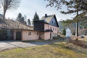 A two-story house with a sloped roof, a garage, and a small attached structure.