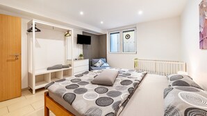 A bedroom with a bed, a wardrobe, a TV, and a window. - Holiday Apartment 'Eifel im Herzen' with Private Terrace, Garden & Wi-Fi (Hambuch)
