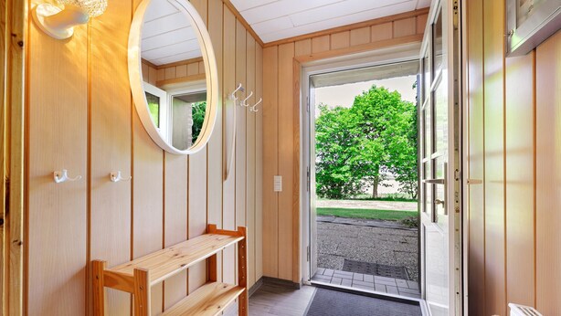 A wooden interior with a bench, a mirror, and a door leading outside. - Apartment 'Norderoog' with Private Terrace, Shared Garden and Wi-Fi (Nordstrand)