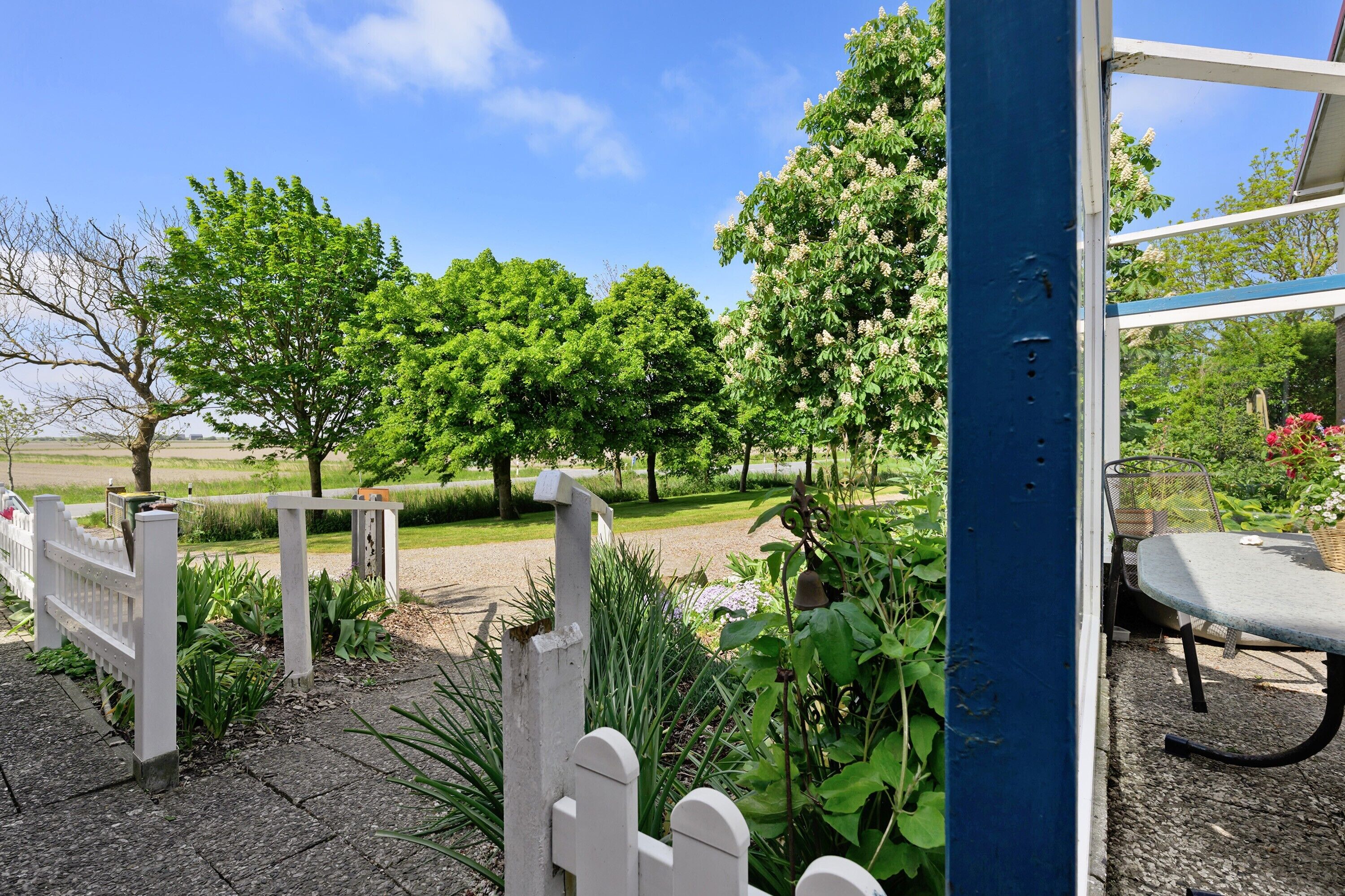 A garden with a white fence, a bench, and a table.