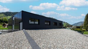 A modern building with a gravel driveway and a clear sky. - Apartment in Tyrol near Kitzbühel (Jochberg in Tirol)