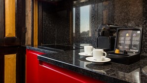 A modern kitchen with a black countertop, two white coffee cups, and a Nespresso machine.