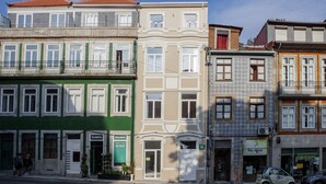 A row of multi-story buildings with distinct architectural styles, including a green facade and a white facade with a balcony. - Charming 1-Bedroom Apartment in Oporto (Oporto)