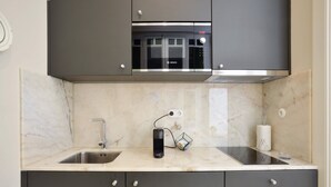 A modern kitchen with a Bosch microwave, a built-in oven, a sink, and a coffee machine.