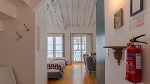 Una habitación con cama, escritorio y extintor en la pared.
