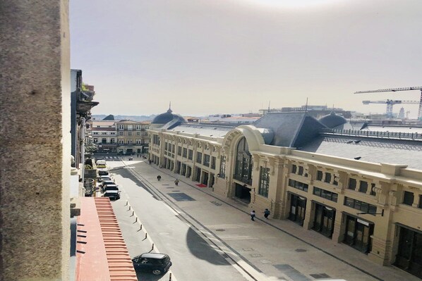 A street view with a building featuring arched windows and a dome.