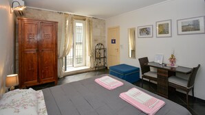 A hotel room with a bed, a desk, a chair, a wardrobe, and a window with curtains. - Nice home in Modica with WiFi (Modica)