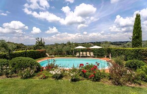 A swimming pool surrounded by lush greenery and a clear sky. - Cozy home in Castelfiorentino (Castelfiorentino)
