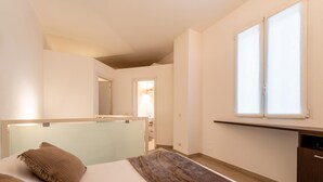 A modern bedroom with a bed, a bedside table, and a large window. - Viale Lecco 105 in Como (Como)
