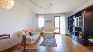 A living room with a sofa, armchairs, a dining table, and a bookshelf. - 2 bedroom beautiful home in Cisano di Bardolino (Cisano di Bardolino)