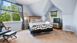 A bedroom with a bed, a chair, a TV, and a window with curtains. - Point of View (Fairview)