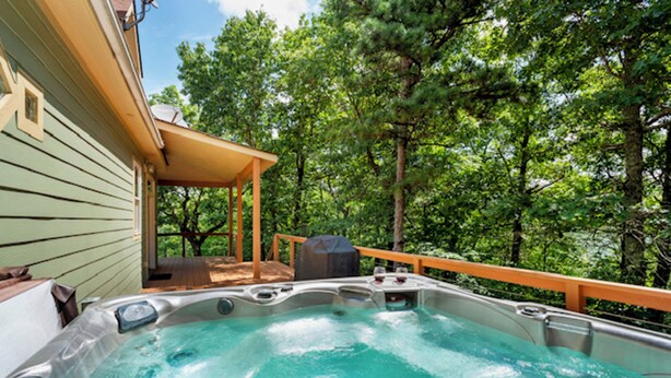 A hot tub on a wooden deck with a view of a forest. - Point of View (Fairview)