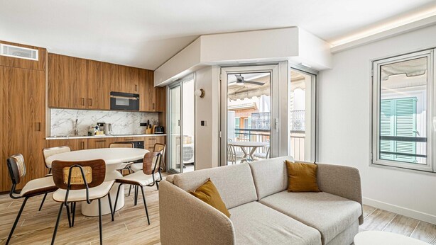 Ein modernes Apartment mit Küche, Essbereich und Wohnzimmer.