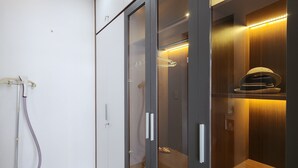 Una habitación moderna con armario, aspiradora y estante de madera.