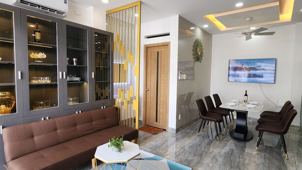 Una sala de estar moderna con un sofá marrón, una mesa de centro y un comedor con sillas y una mesa.