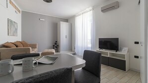 A modern living room with a sofa, coffee table, and TV. - Italianway Easy - Ticinese 83, 15 min to Linate (Milan)