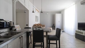 A modern kitchen with a dining area, a sofa, and a TV. - Italianway Easy - Ticinese 83, 15 min to Linate (Milan)