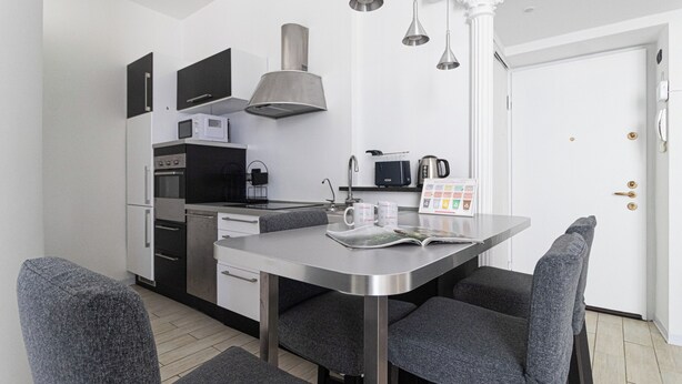 A compact kitchen with modern appliances, a dining table with chairs, and a coffee machine. - Italianway Easy - Ticinese 83, 15 min to Linate (Milan)