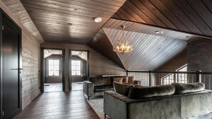 Un loft spacieux avec un haut plafond, un grand canapé et un lustre.