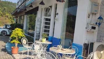 A building with outdoor seating and a white and blue facade.