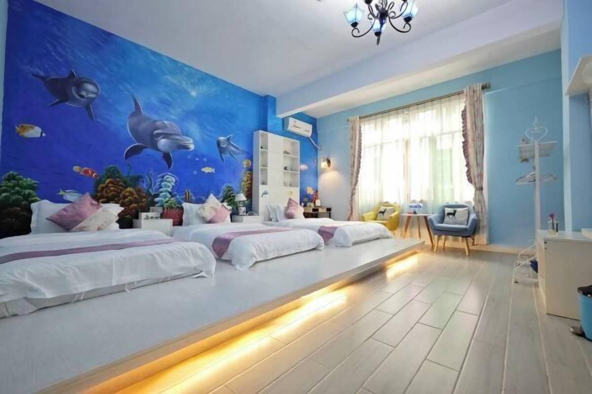 A bedroom with a bed, a nightstand, a dresser, and a window with curtains.