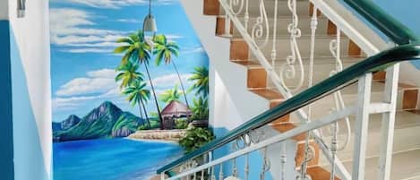 A staircase with a mural of a tropical beach scene.