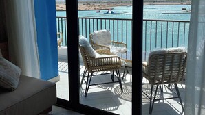A balcony with wicker chairs and a view of a beach and mountains. - Aladdin Chalets - 2.5 Bedrooms (Aqaba)