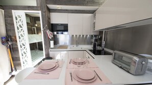 Eine moderne Küche mit weißen Schränken, Edelstahlgeräten und einem eingebauten Toaster.