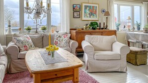 A cozy living room with a wooden coffee table, two sofas, a wooden cabinet, and a chandelier. - 3 bedroom cozy apartment in Myklebost (Myklebost)